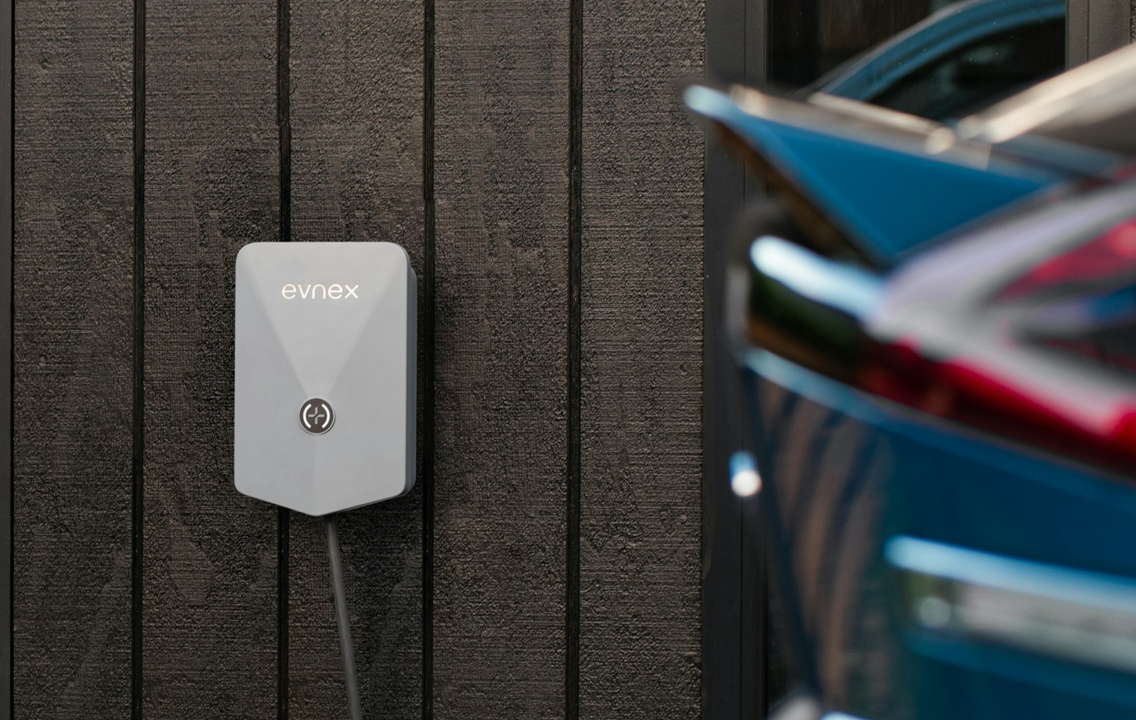 Borne de recharge murale installée chez un particulier, voiture électrique branchée